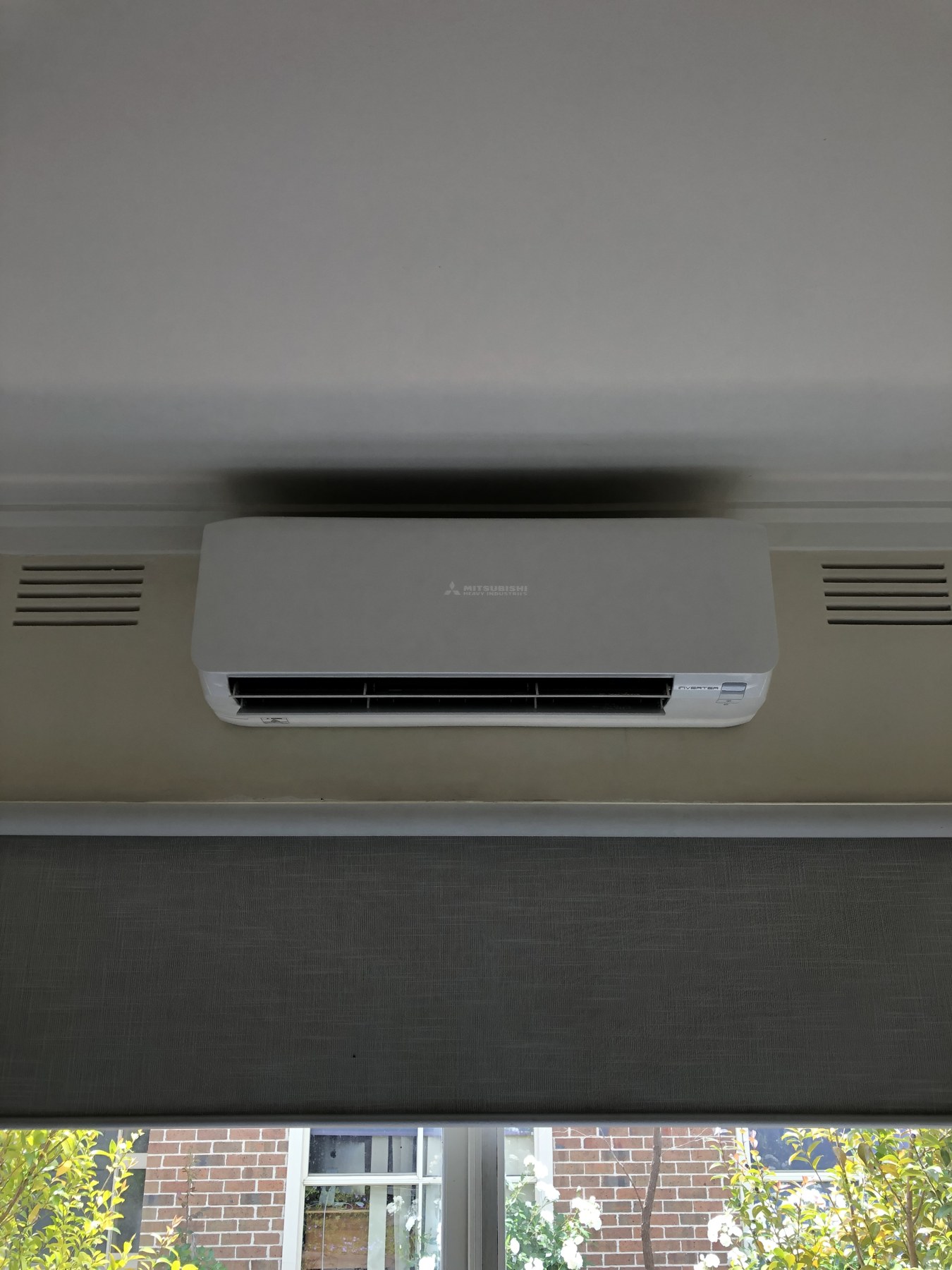 Indoor split system installed above a window blind